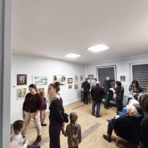 Na zdjęciu uczestnicy wernisażu oglądający prace rozmieszczone na ścianach 