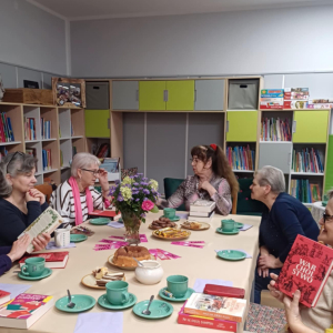 Na zdjęciu widać uczestniczki Dyskusyjnego Klubu Książki siedzące przy stole
