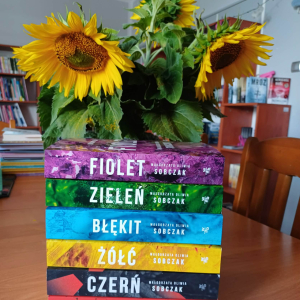 Zdjęcie przestawia 6 książek Małgorzaty Oliwii Sobczak, ustawionych jedna na drugiej. Książki mają żywo kolorowe okładki odpowiadające tytułom. Patrząc od dołu:"Czerwień", "Czerń","Żółć","Błękit","Zieleń","Fiolet".kolorowych okładkach 